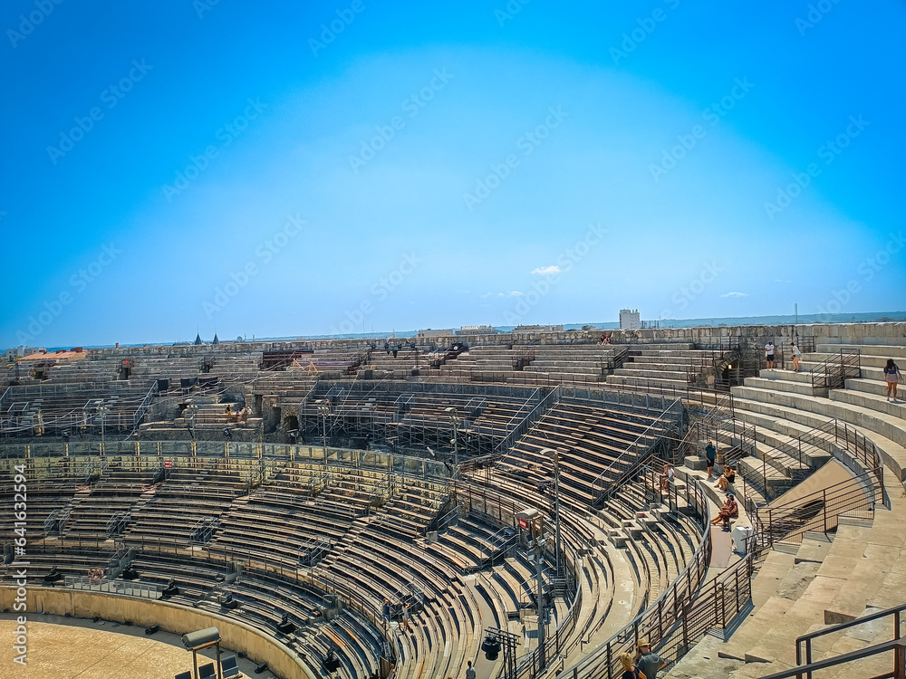 vue de l'intérieur des Arènes de Nîmes sous un ciel bleu