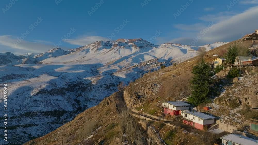Aerial establishing shot of the Farellones in the distance on a snowy Andean Mountain Aerial establishing shot of the Farellones in the distance on a snowy Andean Mountain