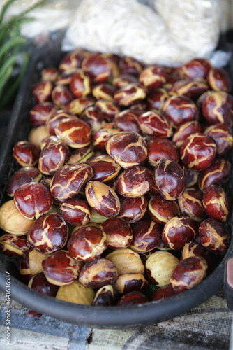 Archidendron pauciflorum, commonly known as Djenkol or Jengkol , displaying and saling in traditional market  photo