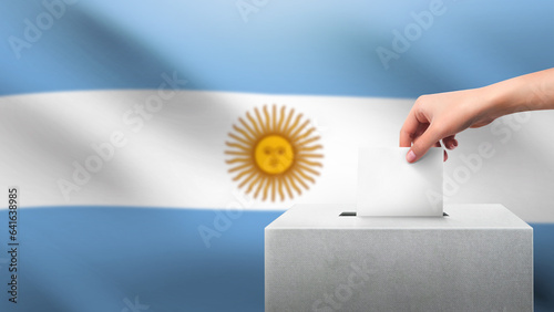 Woman puts ballot paper in voting box on Argentina flag background. Election concept.
