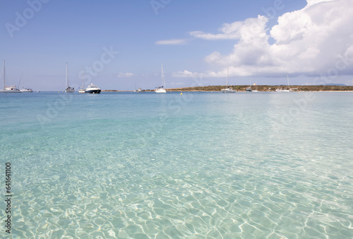 Tranquil beach with sailing boat on clear blue ocean. Formentera Island. Baleares