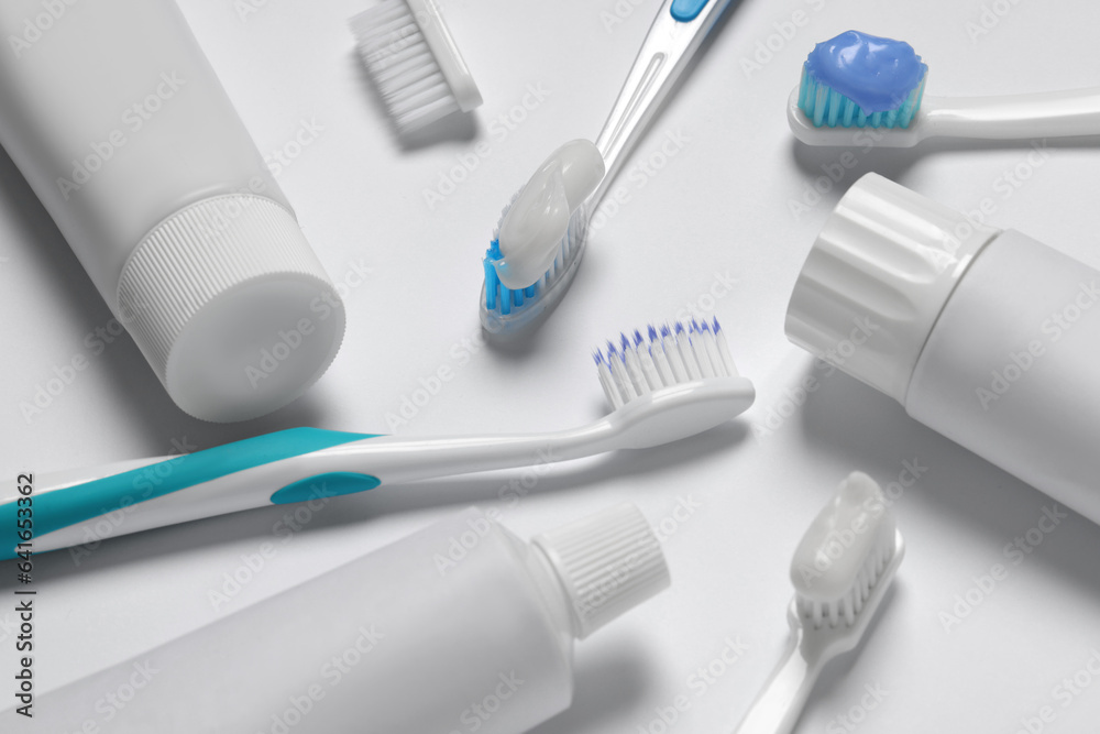Composition with plastic toothbrushes and paste on white background Composition with plastic toothbrushes and paste on white background
