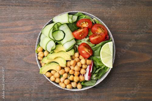 Tasty salad with chickpeas and vegetables on wooden table, top view