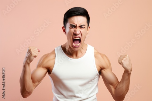Anger Asian Man In A White Tank Top On Pastel Background . Сoncept Representation Of Asian Men, The Power Of Fashion, Mental Health Implications Of Anger, Impact Of Color In Photography
