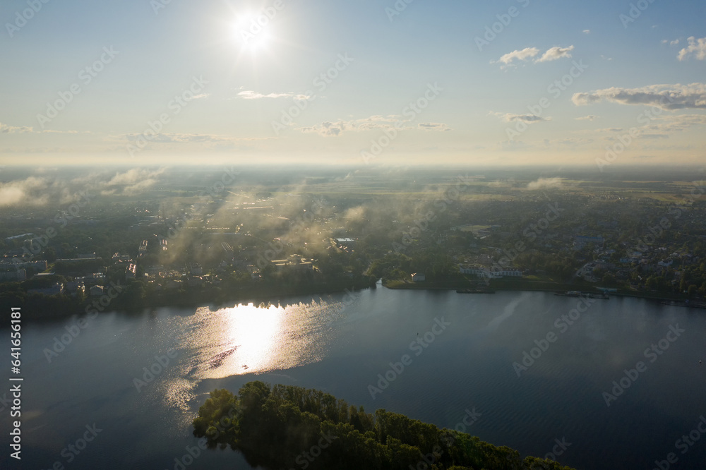 Uglich, Russia. Flying in the clouds. The Volga river embankment in the backlight. Aerial view