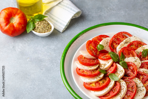 Italian caprese salad with sliced tomatoes, mozzarella, basil, olive oil