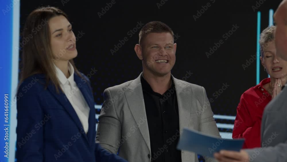 Funny charismatic host talking to the contestants during recording of a fictional morning family game show Funny charismatic host talking to the contestants during recording of a fictional morning family game show