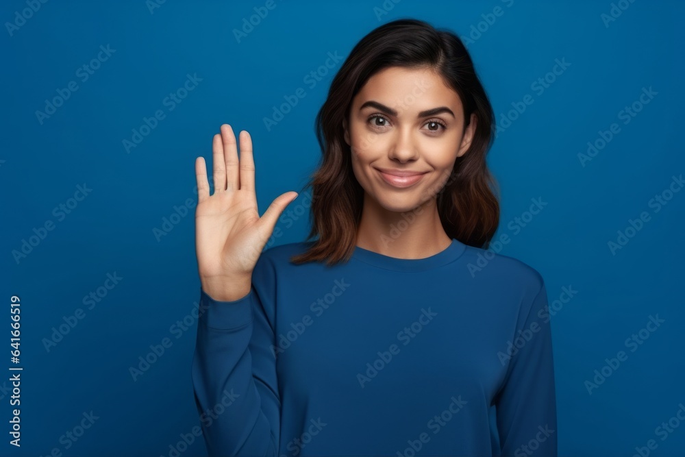 Medium shot portrait photography of a satisfied girl in her 20s making a no or stop gesture with the extended palm against a royal blue background. With generative AI technology Medium shot portrait photography of a satisfied girl in her 20s making a no or stop gesture with the extended palm against a royal blue background. With generative AI technology