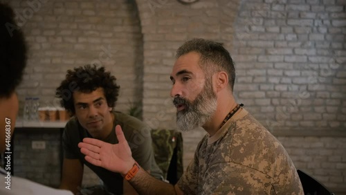 Group of diverse veterans talking during PTSD support group.