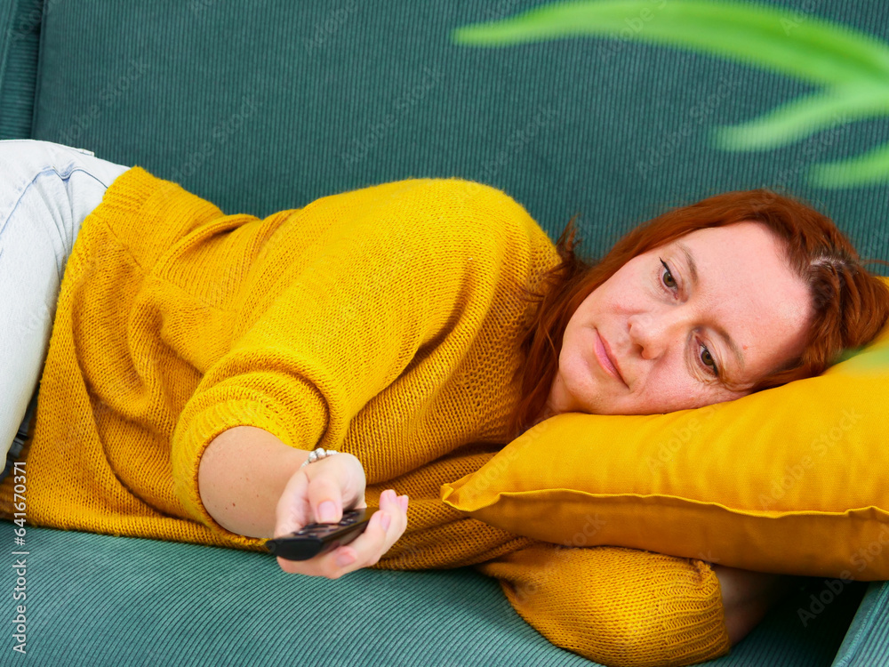 procrastination. Woman lying on sofa and holding remote control. leisure and leisure activity.