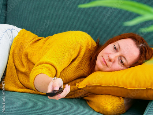 Obraz na płótnie procrastination. Woman lying on sofa and holding remote control. leisure and leisure activity. w salonie