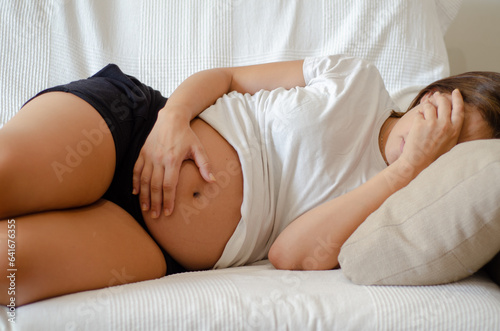 Obraz na plátne Pregnant woman lying on the sofa