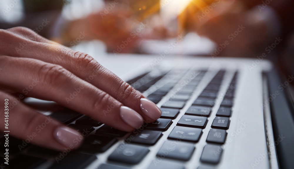 man's hands typing on laptop keyboard in interior