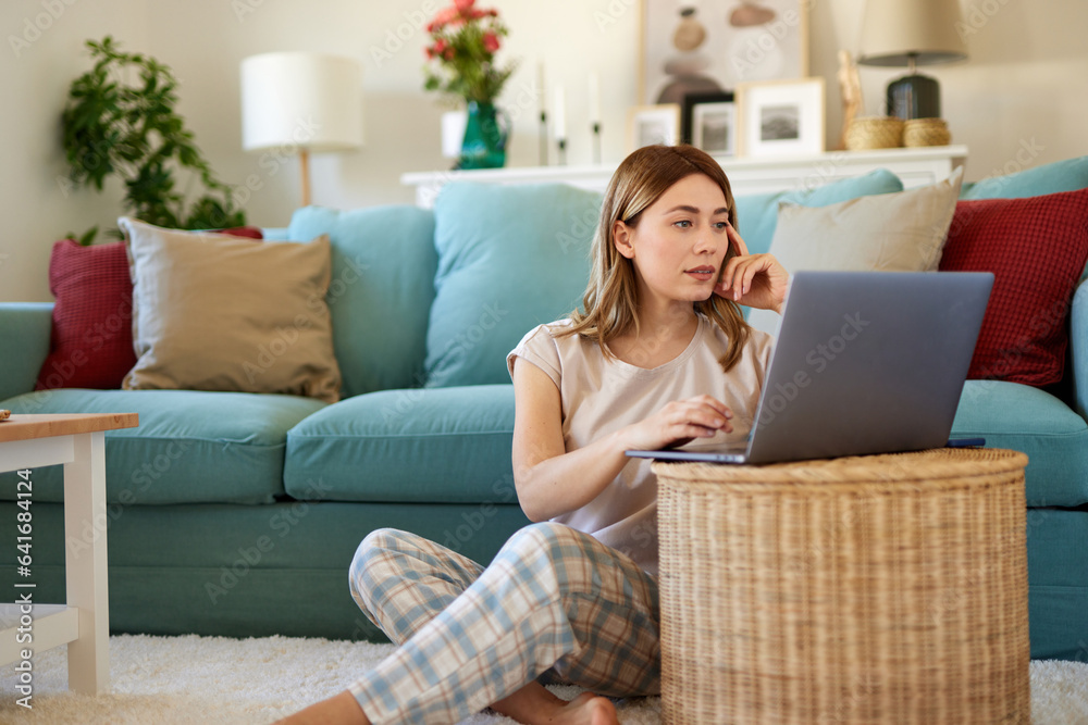 Young woman using a laptop at home Young woman using a laptop at home