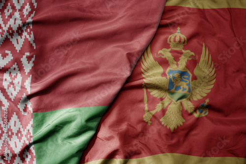 big waving national colorful flag of belarus and national flag of montenegro .
