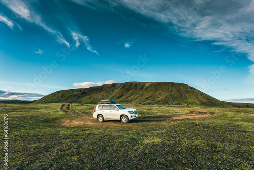 4wd car parked on remote wilderness and mossy hill in summer at Icelandic Highlands photo