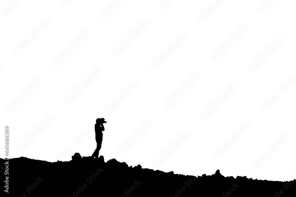 Silhouette of photographer standing with camera taking a photo on the mountain
