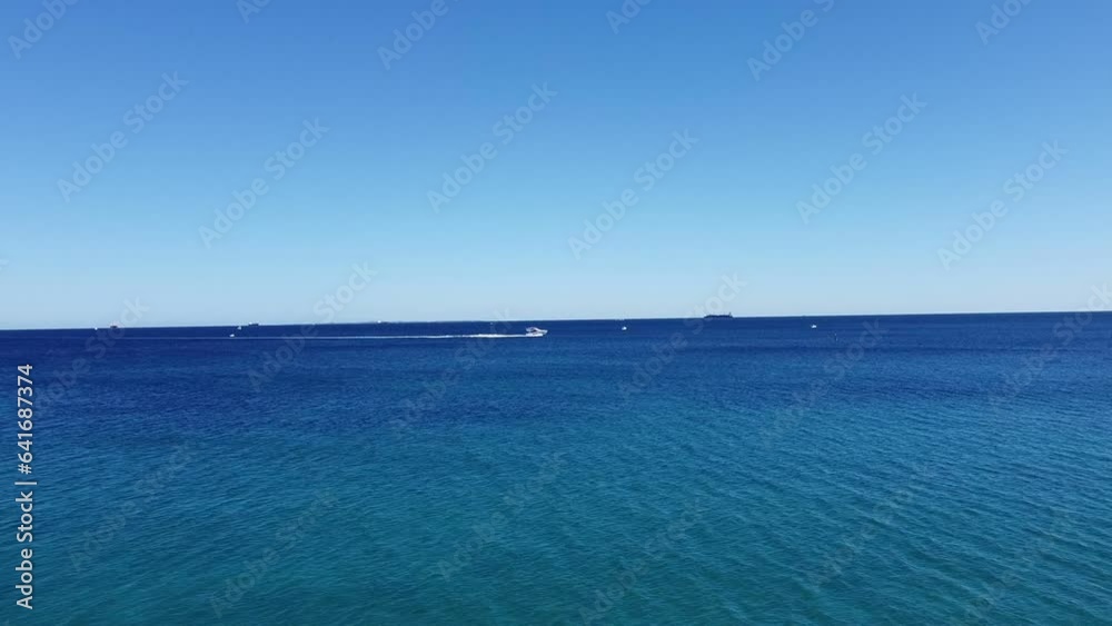 Blue everywhere. Skyline and Seascape background. Speedboat, slow motion Blue everywhere. Skyline and Seascape background. Speedboat, slow motion