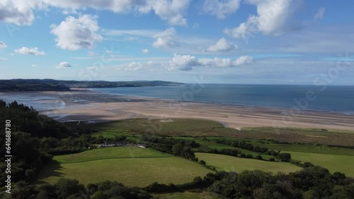 CInematic 4K drone clip towards the Irish Sea over the breathtaking fields by Red Wharf Bay in Anglesey, Wales, UK with village of Benllech in background photo