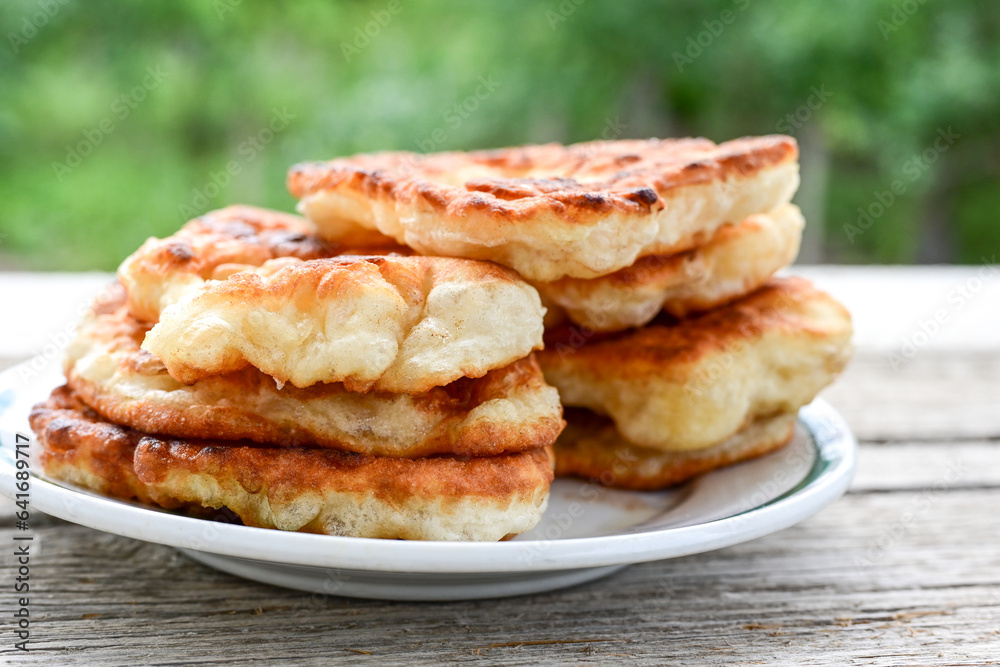 Traditional Bulgarian home made deep fried patties covered with sugar оn rustic backgroud.Mekitsa or Mekica, on wooden rustic background. Made of kneaded dough that is deep fried Traditional Bulgarian home made deep fried patties covered with sugar оn rustic backgroud.Mekitsa or Mekica, on wooden rustic background. Made of kneaded dough that is deep fried