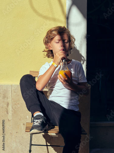 Boy drinking juice near building