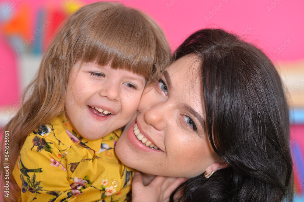 Happy beautiful young mother holding her little cheerful daughter Happy beautiful young mother holding her little cheerful daughter