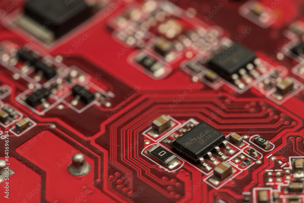 Shallow focus close-up shot of electronic circuit board components in red. Perfect for backgrounds on technology-related topics. Depending on our experiences and ideas, we can interpret many meaning. Shallow focus close-up shot of electronic circuit board components in red. Perfect for backgrounds on technology-related topics. Depending on our experiences and ideas, we can interpret many meaning.