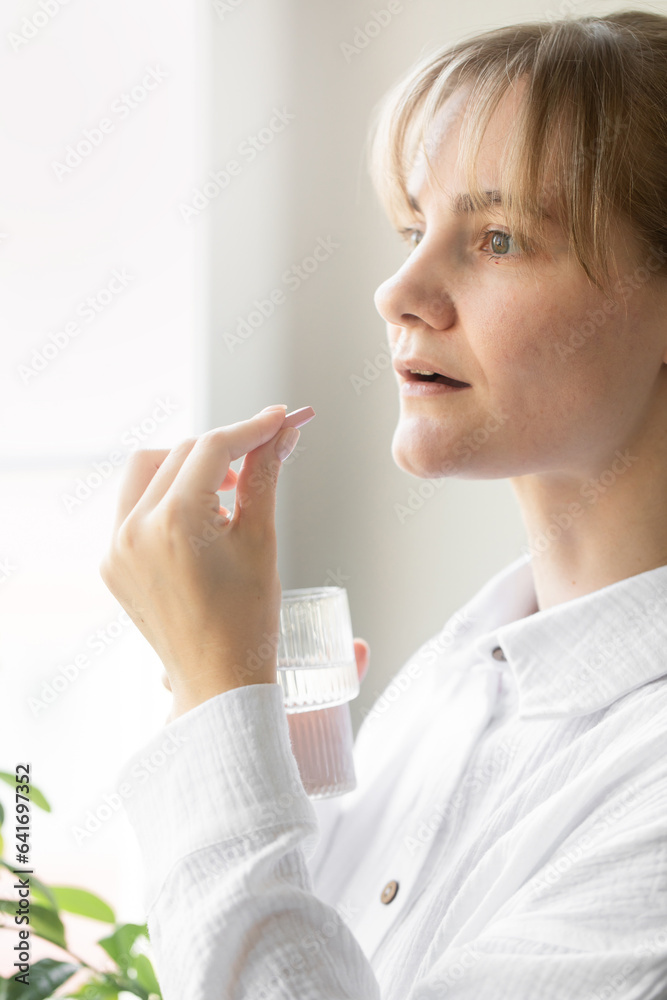 A woman holds a pill in her hand. Taking medications, vitamins. A woman holds a pill in her hand. Taking medications, vitamins.