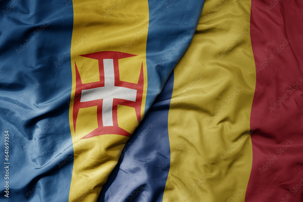 Fototapeta premium big waving national colorful flag of madeira and national flag of romania .