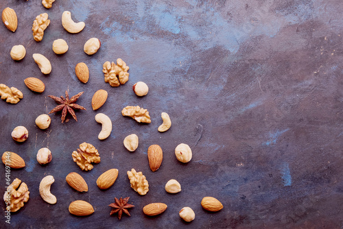 Aesthetic repeated pattern with assorted nuts on rustic background. Hazelnuts , walnuts, almonds, cashews. Healthy snacks and desserts. Copy space