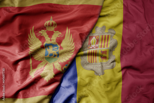 big waving national colorful flag of montenegro and national flag of andorra .