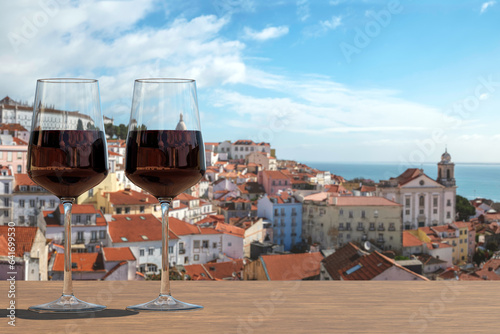 Two glasses of red wine on view of the Lisbon old town in Alfama district in Lisbon, Portugal