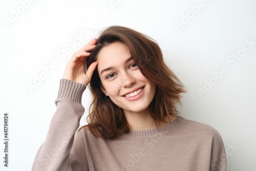 Lifestyle portrait photography of a grinning girl in her 20s making a gesture of i'm thinking with the finger on the head against a pearl white background. With generative AI technology