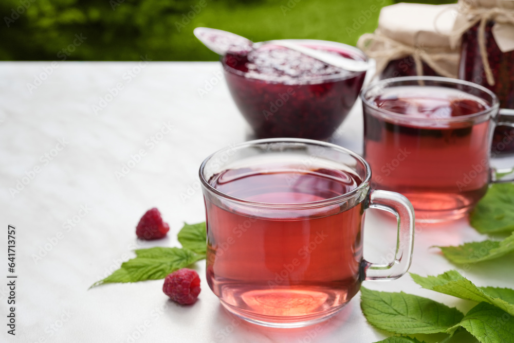 Tea herbal drink from raspberry in glass cups on light background. Side view. Copy space. Tea herbal drink from raspberry in glass cups on light background. Side view. Copy space.