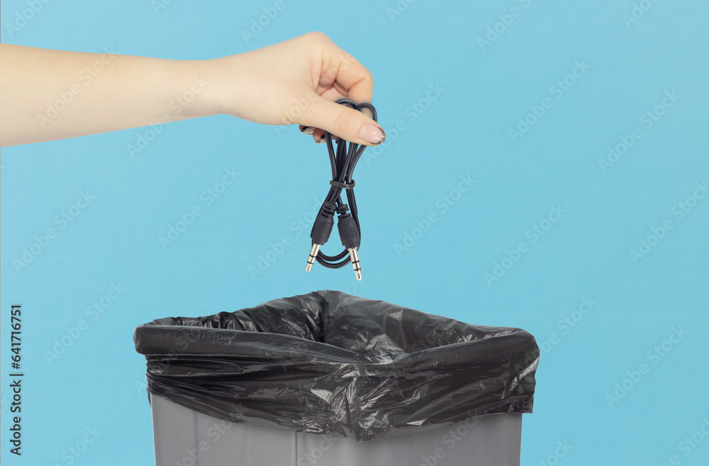 throw away TRRS audio jack, aux cable in trash can, cable in hand in