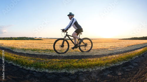 man cyclist rides a bike on a road in nature. sports, cycling and health hobbies © photosaint
