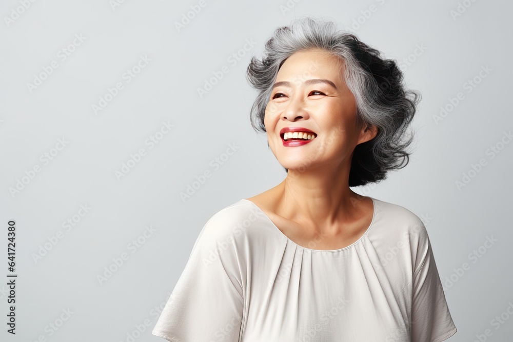 Portrait of a stylish beautiful Asian woman in her 50s. Skin care concept. Luxurious middle-aged woman with a short gray hair looking at copy space. Portrait of a stylish beautiful Asian woman in her 50s. Skin care concept. Luxurious middle-aged woman with a short gray hair looking at copy space.