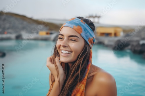 Medium shot portrait photography of a happy girl in her 20s coughing wearing a colorful bandana at the blue lagoon in reykjavik iceland. With generative AI technology
