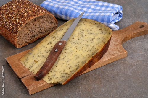 Cuadro en lienzo Morceau de tomme à l'ail des ours avec un couteau sur une planche à découper en