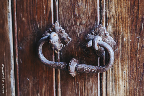 Détail de décor en fer forgé sur une porte ancienne en bois dans un château médiéval