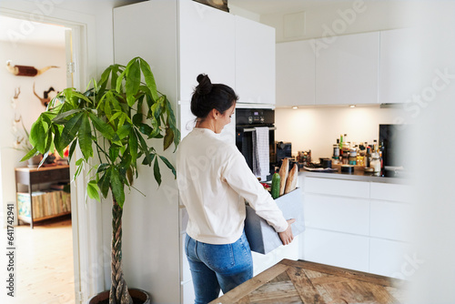 Woman carrying groceries in her kitchen photo