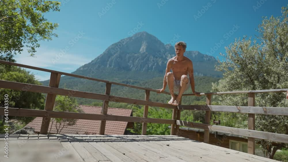 athletic aged sports man doing bodyweight push up and core exercises outdoors on wooden terrace outdoors. sport exercise with beautiful mountains background. active lifestyle. using mobile app athletic aged sports man doing bodyweight push up and core exercises outdoors on wooden terrace outdoors. sport exercise with beautiful mountains background. active lifestyle. using mobile app