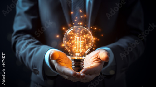 A bright idea. Light bulb concept. Business growth. Innovation.  A businessman holding a lightbulb.  Entrepreneur or entrepreneurialism.  