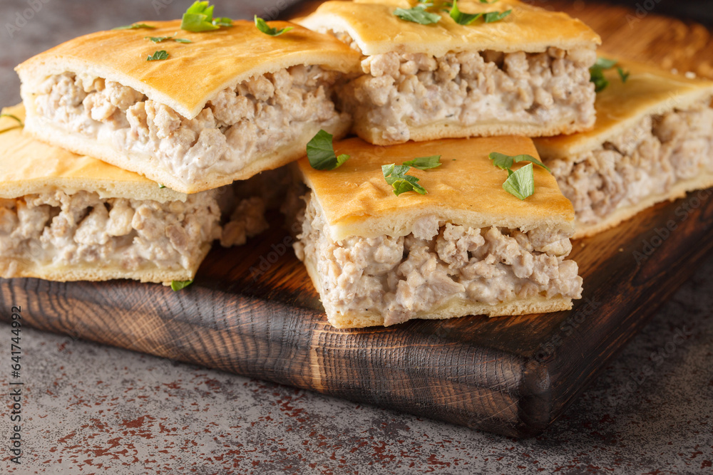 Savory pie for breakfast of italian sausages with cream cheese close-up on a wooden board on the table. horizontal Savory pie for breakfast of italian sausages with cream cheese close-up on a wooden board on the table. horizontal