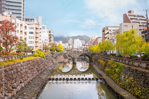 Nagasaki, Japan - Nov 29 2022: Meganebashi Bridge is the most remarkable of several stone bridges. The bridge gets its name from the resemblance of spectacles when reflected in the river water photo