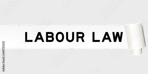 Ripped gray paper background that have word labour law under torn part
