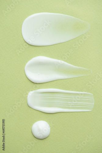 Macro texture of white cream on a green background