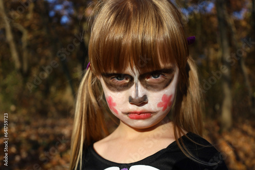Portrait of little girl with sugar skull makeup of Calavera Catrina. Masquerade costume and painted face for Day of Dead, Dia de los Muertos. Halloween skeleton character, creepy angry zombie.