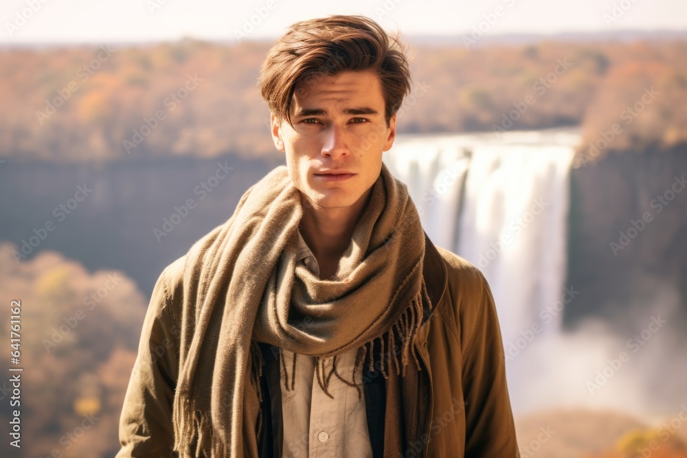 Medium shot portrait photography of a glad boy in his 20s wearing an elegant silk scarf at the victoria falls in livingstone zambia. With generative AI technology Medium shot portrait photography of a glad boy in his 20s wearing an elegant silk scarf at the victoria falls in livingstone zambia. With generative AI technology