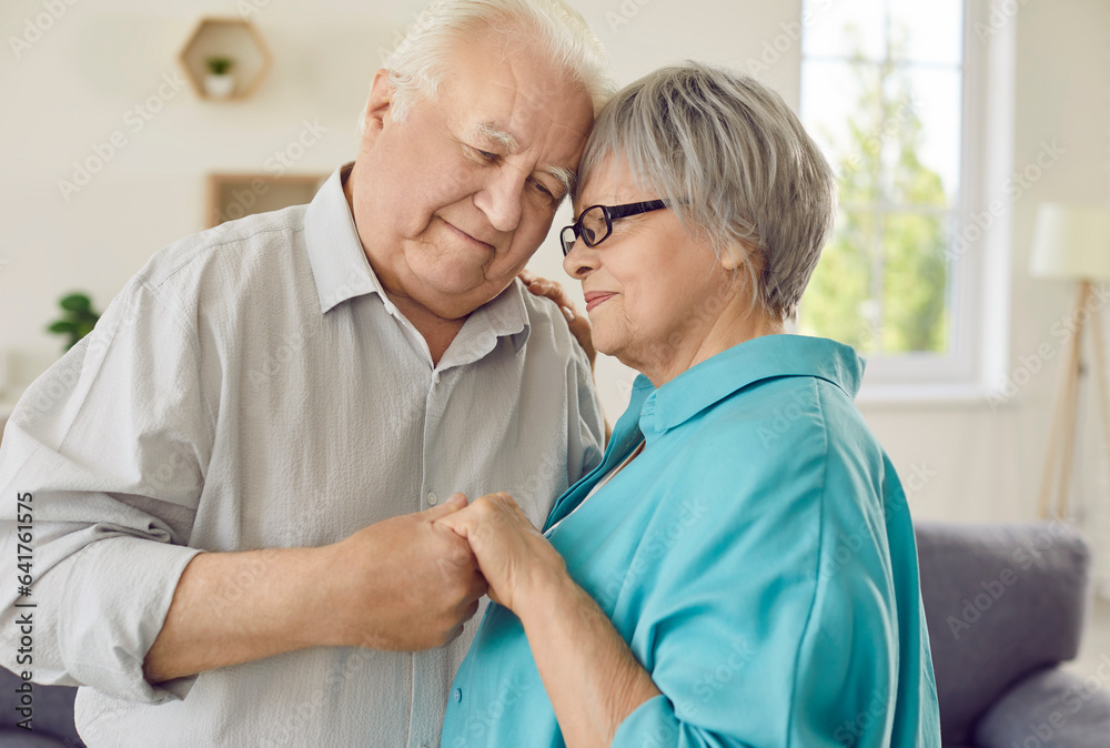 Obraz premium Happy loving white and grey haired senior man and woman holding hands and smiling. Retiree couple cherishing relationship of partnership, companionship, mutual appreciation, respect and understanding